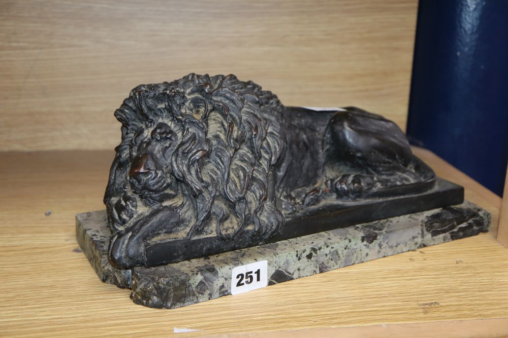 After Canova, a bronze recumbent lion, on a marble plinth, length 35.5cm